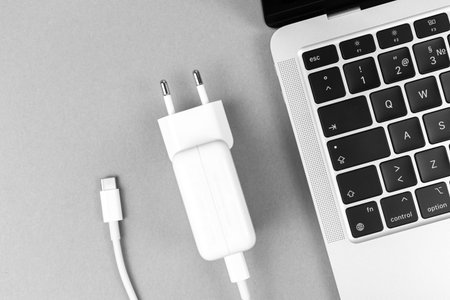 Modern USB Type C charger for laptop. Low battery concept, technology background, office table top...