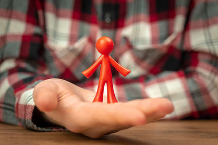 Figurine of human in hand. Concept of fatherhood, continuation and parenting background photoの写真素材