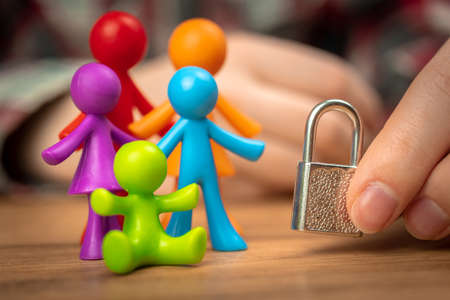 Family problems, plastic colorful figurines on wooden table with padlock. Divorce in family with children, conflict, crisis conceptの写真素材