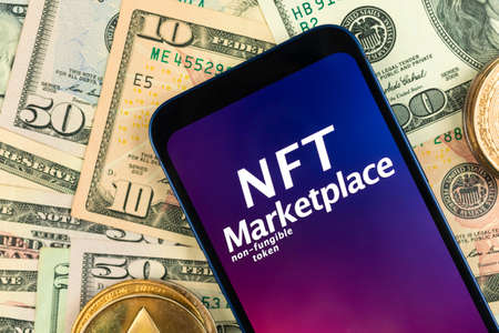 NFT cryptoart marketplace background. Smartphone with NFT application on money background with golden crypto currency coins, top viewの写真素材