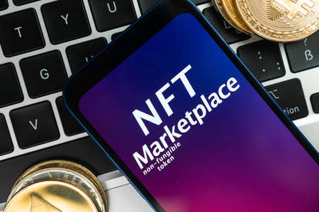 NFT cryptoart marketplace concept. Mobile phone for working with non-fungible token and ethereum coin on laptop keyboard. top viewの写真素材