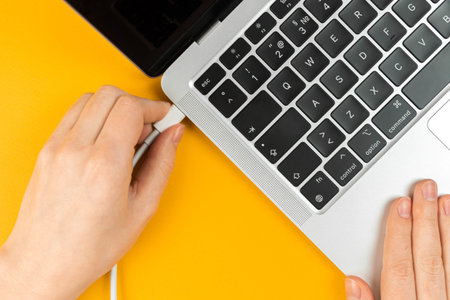 Woman plugging charger in a laptop. Type C charging port. low battery concept