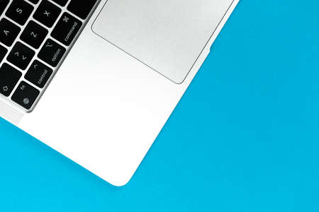 Laptop flat lay blue background. Office workspace table, minimal design concept. top view, copy spaceのeditorial素材