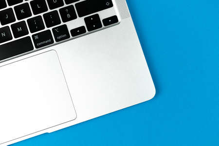 Laptop flat lay blue background. Office workspace table, minimal design concept. top view, copy spaceのeditorial素材