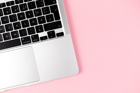 Modern laptop flat lay pink background. notebook keyboard. Office workplace table, minimal design concept. top view, copy spaceのeditorial素材