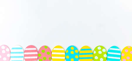 Colorful easter eggs banner design. Happy easter greetings concept, holiday decoration background with copy space, flat lay, top viewの写真素材