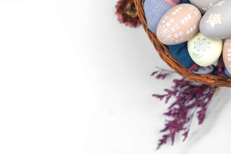 Easter eggs with flowers. Happy holidays, celebration and greeting design on a white background. Flat lat, top view and copy spaceの写真素材