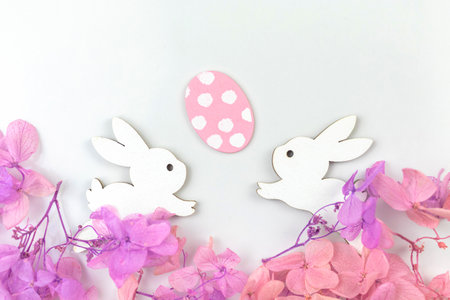 Colorful easter eggs with flowers and rabbits. Happy easter greetings concept, holiday decoration background with copy space, flat lay, top viewの写真素材