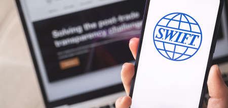 Kharkov, Ukraine - February 27, 2022: SWIFT close-up on mobile phone screen. Woman use SWIFT banking and international technology concept photoのeditorial素材
