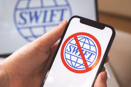 Kharkov, Ukraine - February 27, 2022: SWIFT blocked, close-up on mobile phone screen. Girl use SWIFT banking and international technology concept photoのeditorial素材