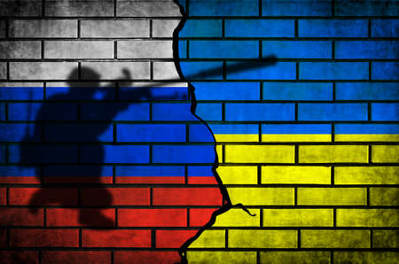 Russia vs Ukraine conflict and war flags background. Military armed men silhouette on brick wall photoの写真素材