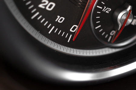 Car speedometer with red indicator close-up view, luxury car interior background