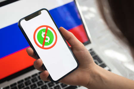 Poltava, Ukraine - March 23, 2022: Banned dollar money in Russian Federation. Dollar logo and Russian flag background. Sanction conceptのeditorial素材
