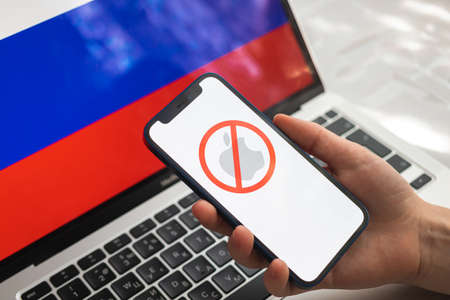 Poltava, Ukraine - March 23, 2022: Apple and Russia flag. Sanctions, ban and banned business. Apple stopped working in Russian Federation, logo close-up photoのeditorial素材