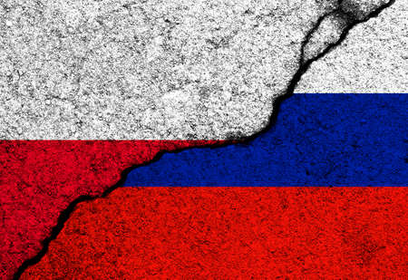 Poland and Russia flags painted on cracked concrete walls backgroundの写真素材