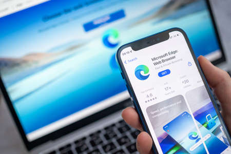 Poltava, Ukraine - March 22, 2022: Microsoft Edge app on the mobile phone screen. Woman using Microsoft Edge browser application, icon close-up view photoのeditorial素材