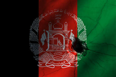 Afghanistan flag with big crack or bullet hole. Military conflict and war in country concept background photoの写真素材