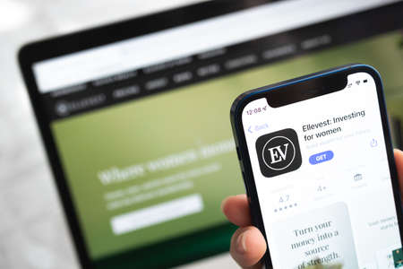 Poltava, Ukraine - April 5, 2022: Ellevest app icon. Invest for women. Hand with mobile phone with application. Mobile banking and investment conceptのeditorial素材