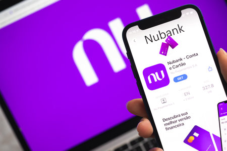 Poltava, Ukraine - April 5, 2022: Nubank app icon. Hand with mobile phone with application. mobile banking conceptのeditorial素材