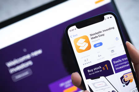 Poltava, Ukraine - April 5, 2022: Stockpile Investing app icon. Hand with mobile phone with application. Mobile banking and investment conceptのeditorial素材