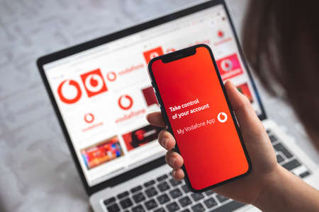 Poltava, Ukraine - April 5, 2022: My Vodafone app. Mobile phone in woman hand with title screen of mobile network photoのeditorial素材