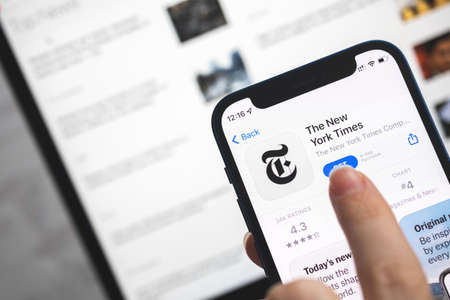 The New York Times app icon. Woman use news application, breaking news concept photoのeditorial素材