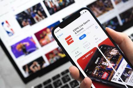 ESPN Live Sports and Scores app icon. Hand with mobile phone with application. Sport concept photoのeditorial素材