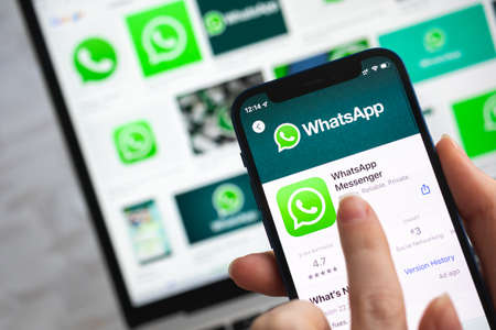 Woman use Whatsapp app. Hand with mobile phone with application. Messenger and social networking concept photoのeditorial素材