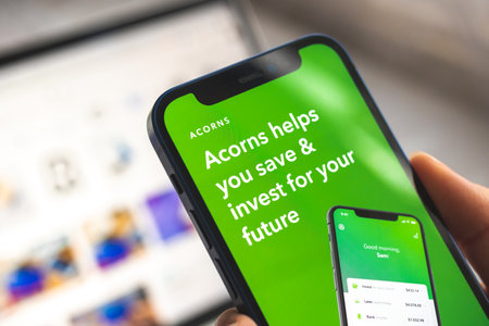Woman use Acorns Invest app. Mobile phone banking and investment concept photoのeditorial素材