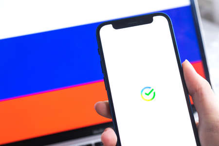SPB, Russia - April 7, 2022: Sberbank mobile banking app in Russia. Hand with smartphone, on the screen. background with national flag photoのeditorial素材