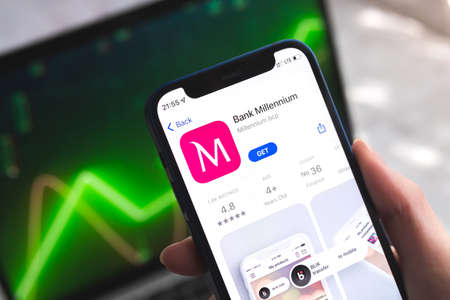 Poltava, Ukraine - April 7, 2022: Bank Millennium mobile banking app in Poland. Hand with smartphone, on the screenのeditorial素材