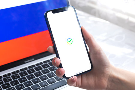 SPB, Russia - April 7, 2022: Sberbank mobile banking app in Russia. Hand with smartphone, on the screen. background with national flag photoのeditorial素材