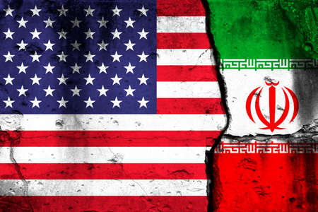 United States and Iran crisis. Background with national flags on cracked wallの写真素材