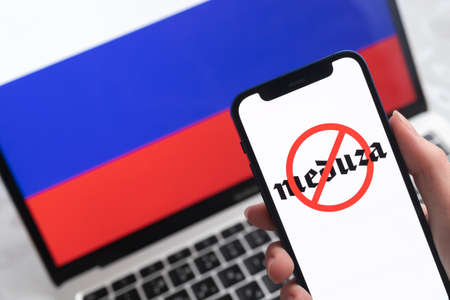 SPB, Russia - April 8, 2022: Meduza in Russia. Blocked and banned service, EU sanctions. Mobile phone with , russian flag background photoのeditorial素材