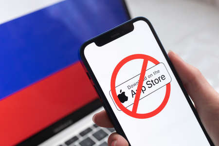 SPB, Russia - April 8, 2022: App Store in Russia. Blocked and banned service, EU sanctions. Mobile phone with , russian flag background photoのeditorial素材