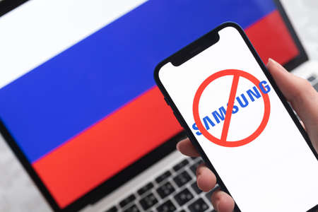 SPB, Russia - April 8, 2022: Samsung in Russia. Blocked and banned service, EU sanctions. Mobile phone with , russian flag background photoのeditorial素材