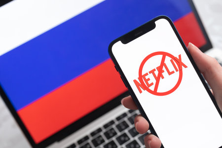 SPB, Russia - April 8, 2022: Netflix in Russia. Blocked and banned service, EU sanctions. Mobile phone with , russian flag background photoのeditorial素材