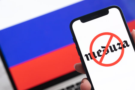 SPB, Russia - April 8, 2022: Meduza in Russia. Blocked and banned service, EU sanctions. Mobile phone with , russian flag background photoのeditorial素材