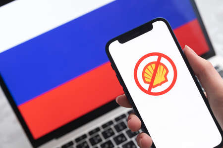 SPB, Russia - April 8, 2022: Shell in Russia. Blocked and banned service, EU sanctions. Mobile phone with , russian flag background photoのeditorial素材