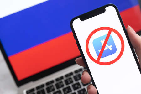 SPB, Russia - April 8, 2022: App Store in Russia. Blocked and banned service, EU sanctions. Mobile phone with , russian flag background photoのeditorial素材