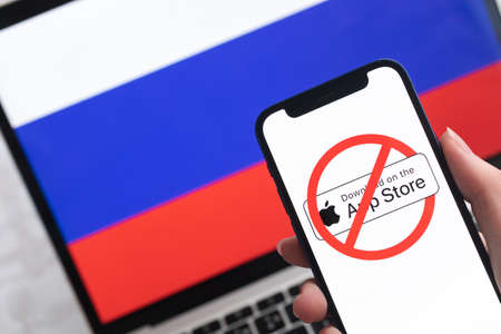 SPB, Russia - April 8, 2022: Apple App Store in Russia. Blocked and banned service, EU sanctions. Mobile phone with , russian flag background photoのeditorial素材
