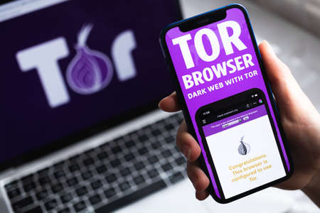 SPB, Russia - April 15, 2022: Person uses Tor Browser with VPN app. Icon close-up. Smartphone with private and safe browser, VPN application photoのeditorial素材