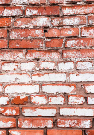Old red brick wall with weathered white paint, high detailed texture backgroundの写真素材