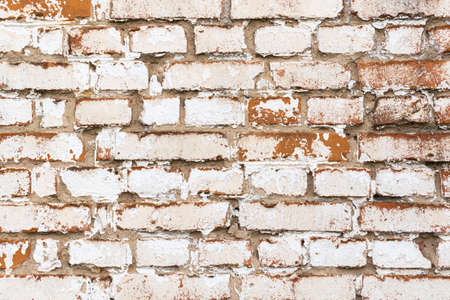 Old brick wall with weathered white paint, high detailed texture backgroundの写真素材