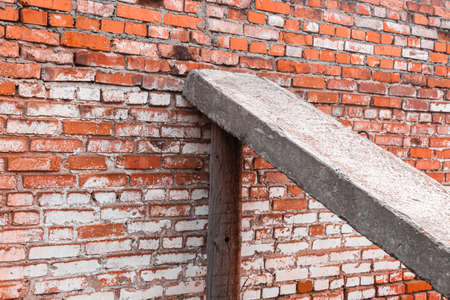 Falling brick wall with prop, old structure and damaged architecture concept backgroundの写真素材