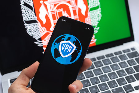 VPN in Afghanistan. Secure and safe internet concept. privacy. Hand with mobile phone and VPN application. Flag and laptop on the background photoの写真素材