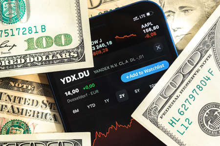 Poltava, Ukraine - April 28, 2022: Yandex stock trade market background, finance and business concept with dollar money banknotes closeupのeditorial素材