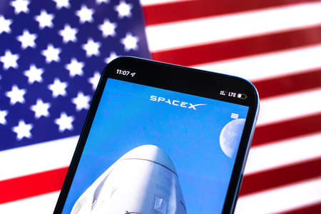 Poltava, Ukraine - April 28, 2022: SpaceX against American flag, USA background. Satellite internet modern technology provided by Elon Musk photoのeditorial素材