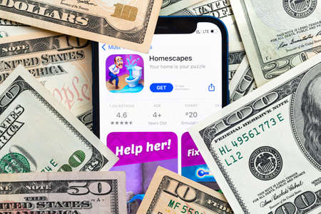 Homescapes mobile game app. Money background. Concept, company making money with popular mobile phone gamesのeditorial素材