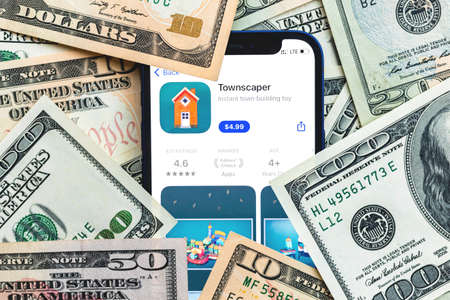 Townscapes mobile game app. Money background. Concept, company making money with popular mobile phone gamesのeditorial素材